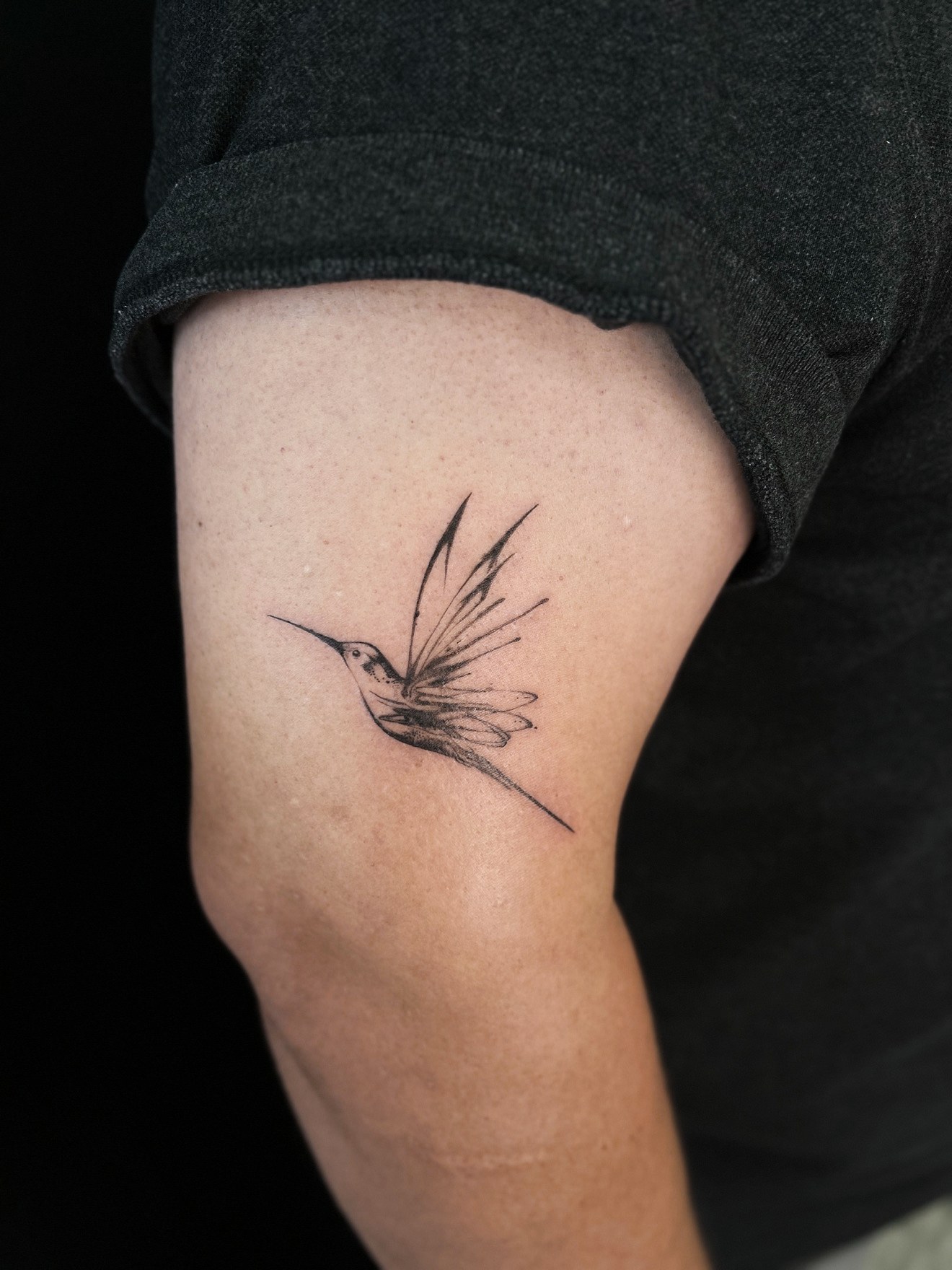 Fine line hummingbird upper arm tattoo by On Point Fine Line Tattoo Studio, Woodridge IL