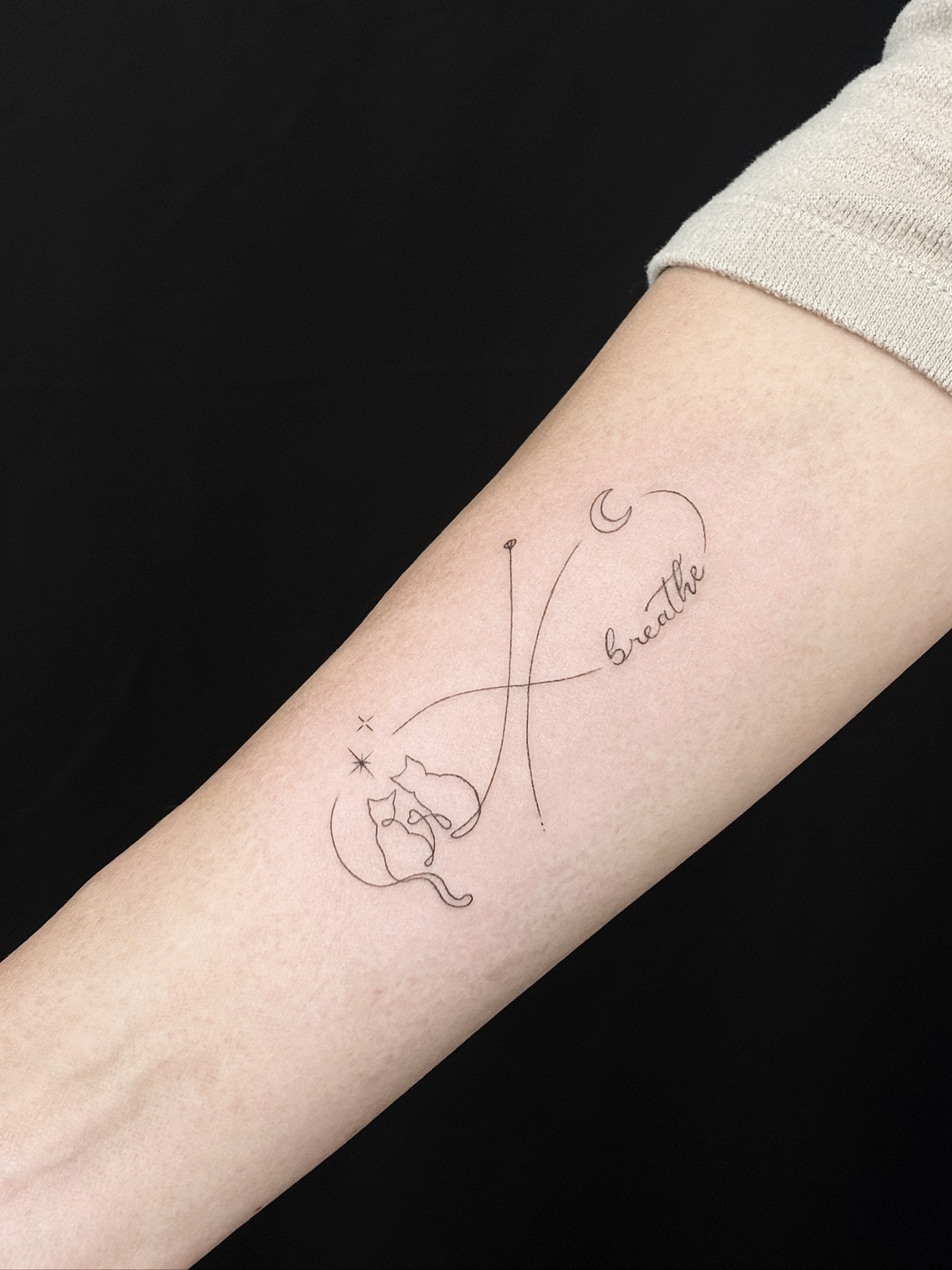Fine line 'breathe' script tattoo with two cats, moon and stars by On Point Fine Line Tattoo Studio, Woodridge IL