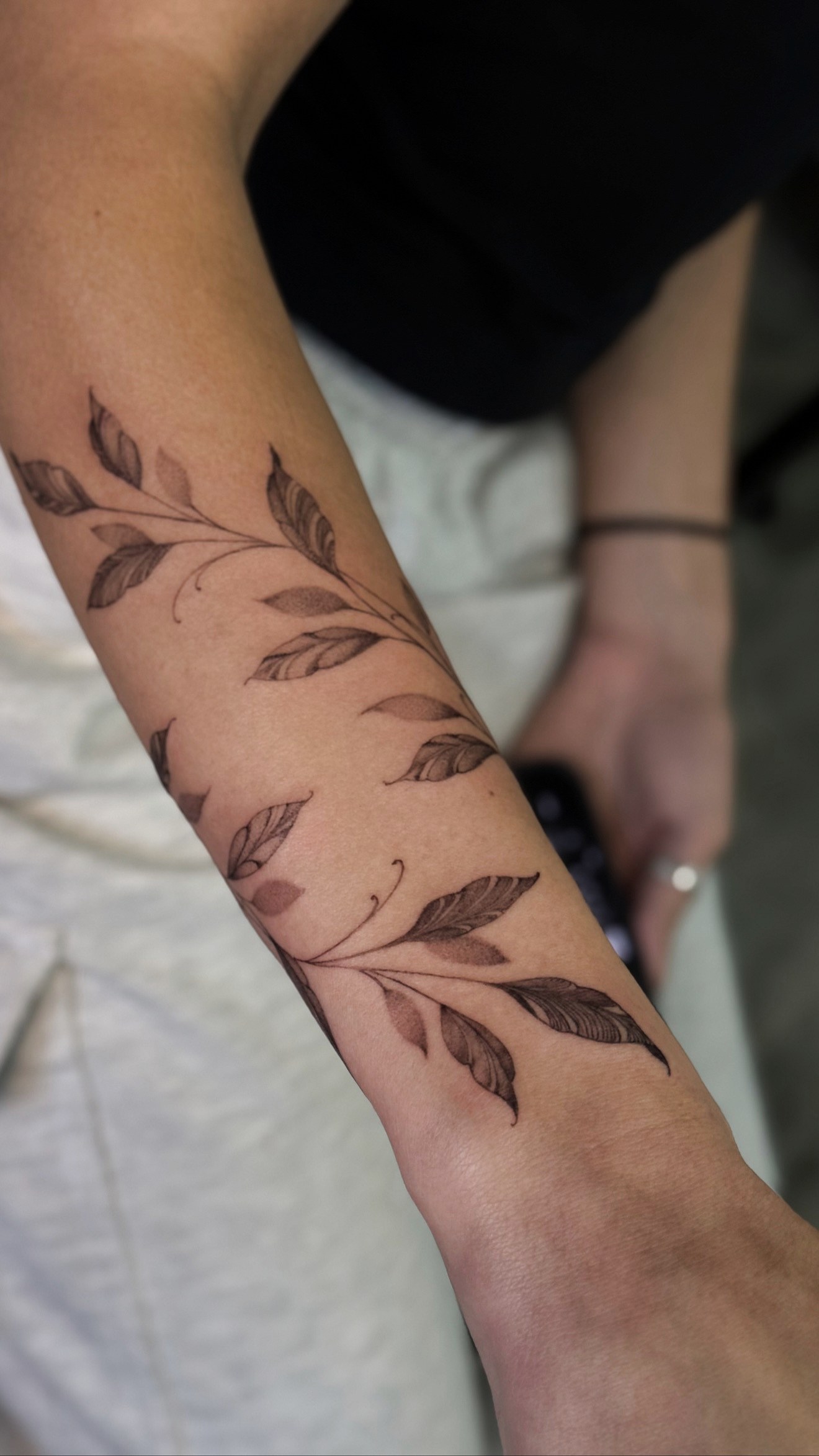 Fine line leaf vine forearm wrap tattoo by On Point Fine Line Tattoo Studio, Woodridge IL