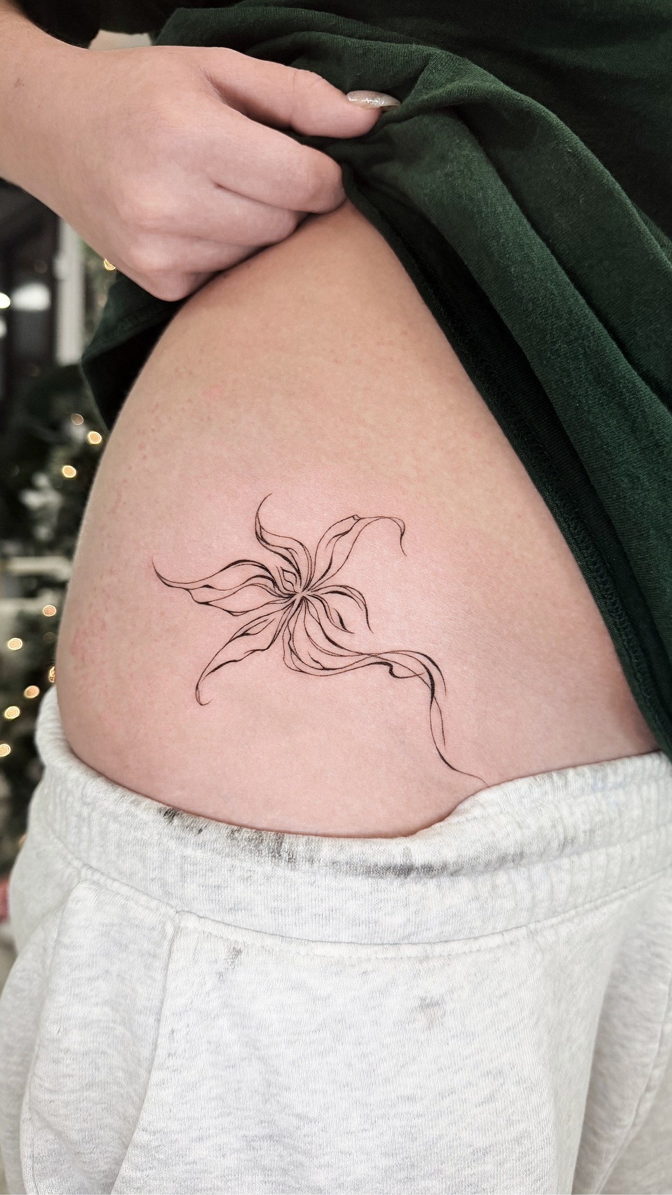 Fine line abstract flowing-line bloom hip tattoo by On Point Fine Line Tattoo Studio, Woodridge IL